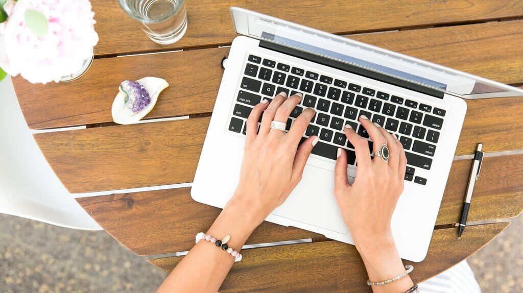 Person typing meeting minutes on a laptop